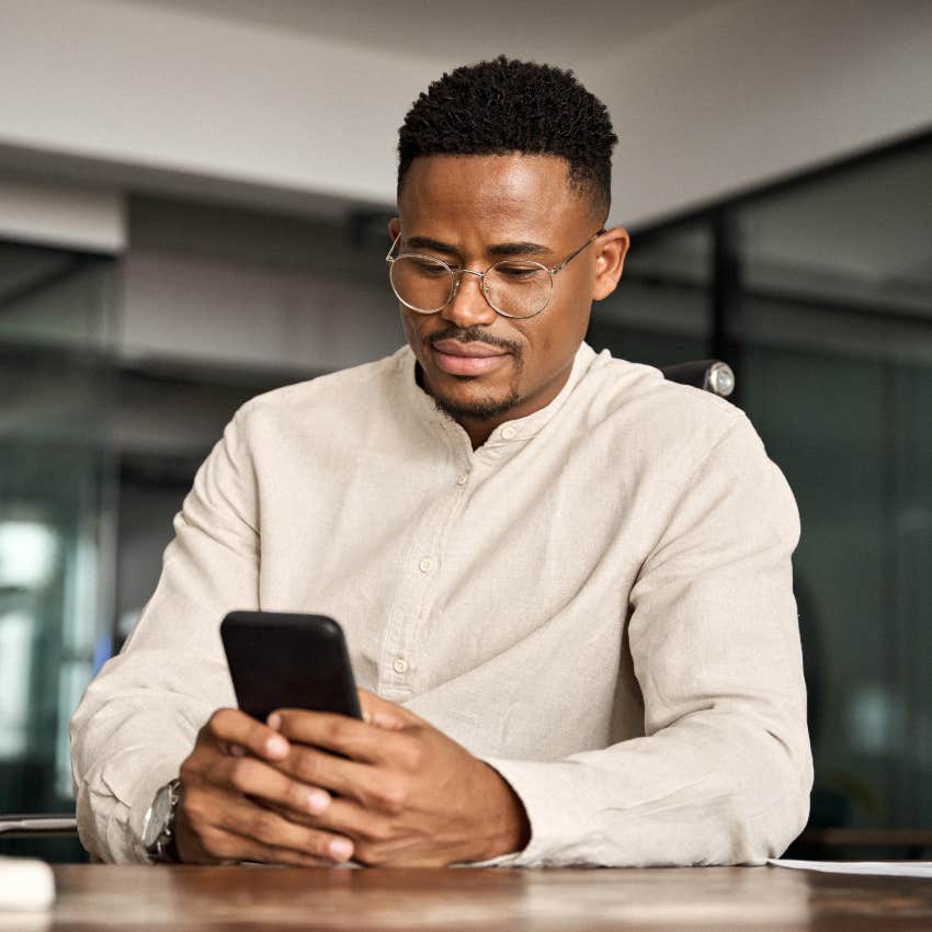 man experiencing cognitive overload checking his phone