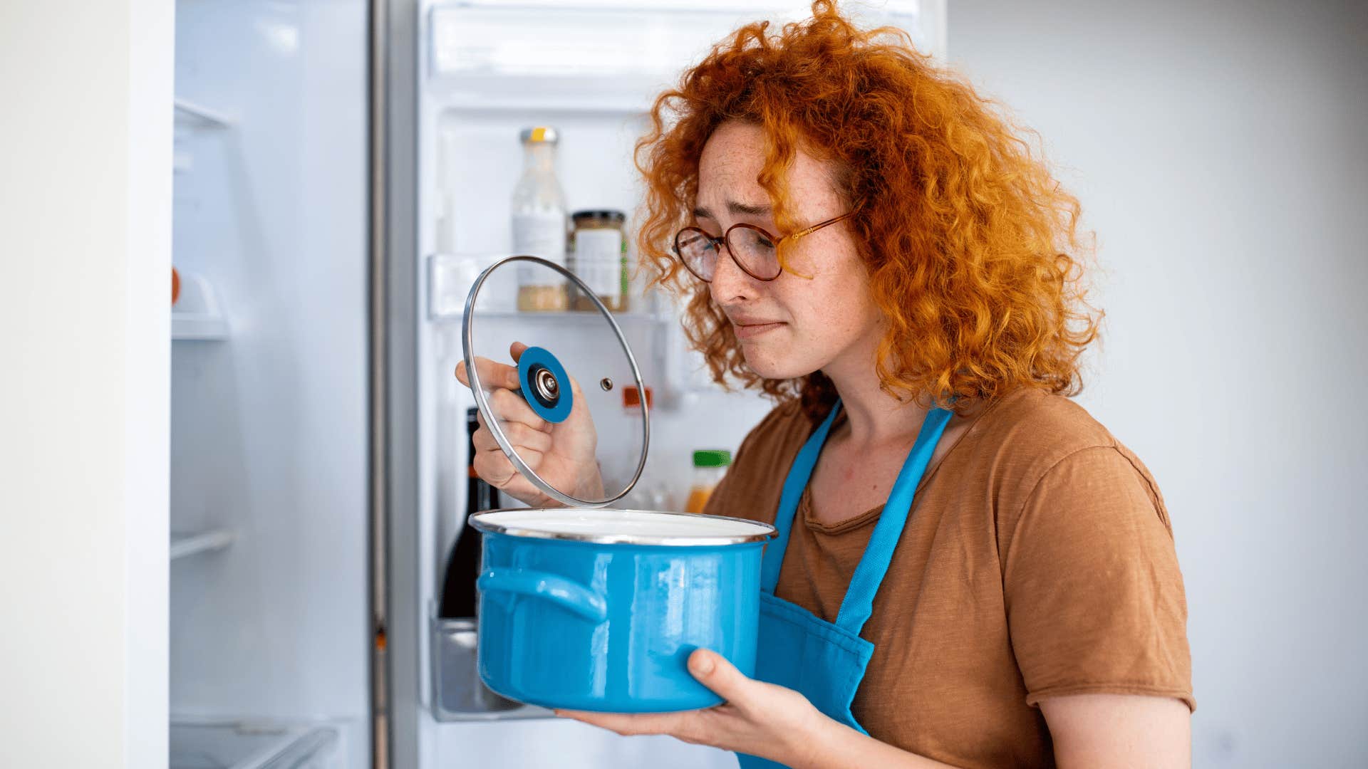 woman in brown shirt upset as she doesn't argue how leftovers should be stored in the fridge