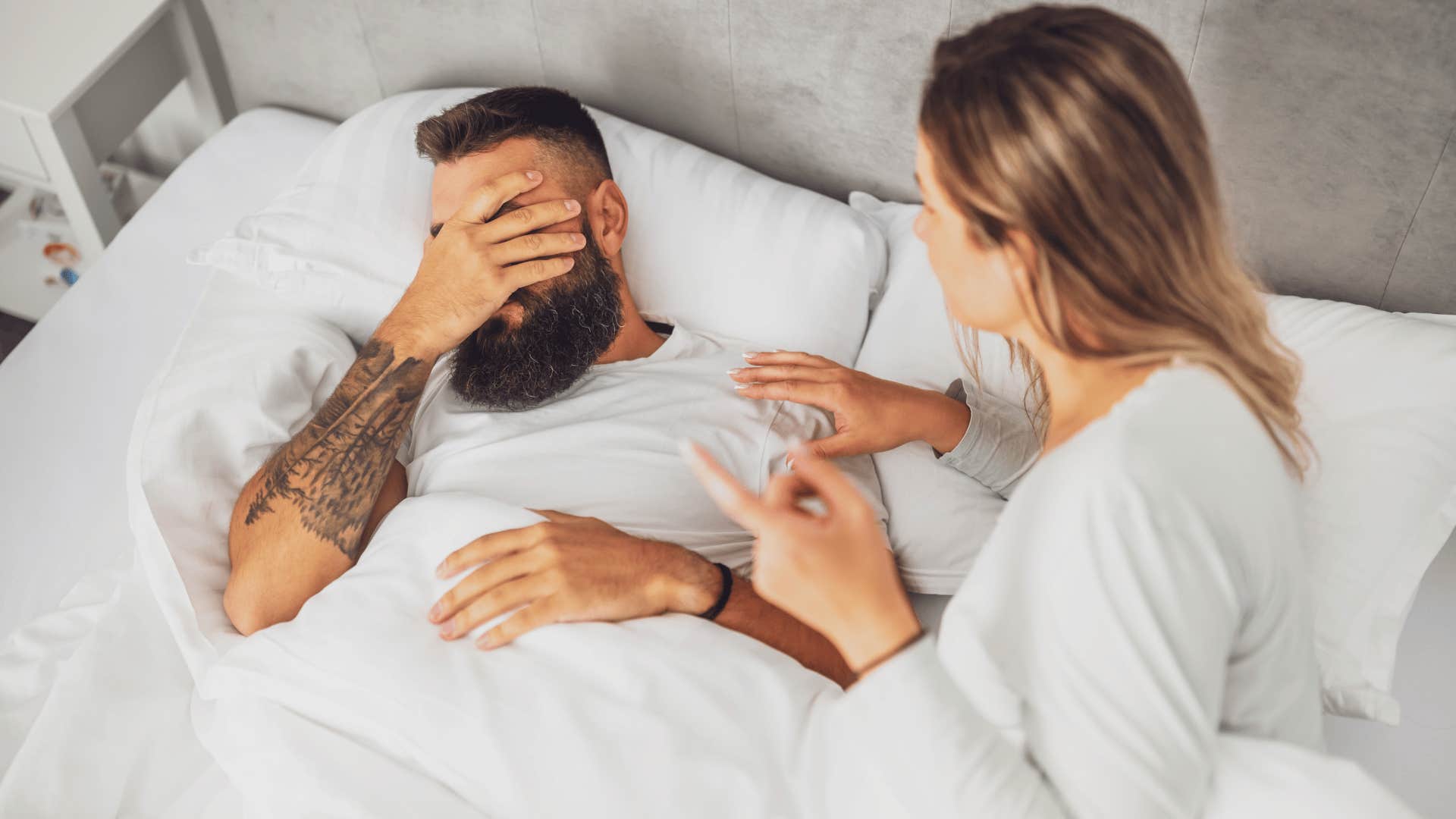 woman waking up man upset as they argue about what temperature the house should actually be at