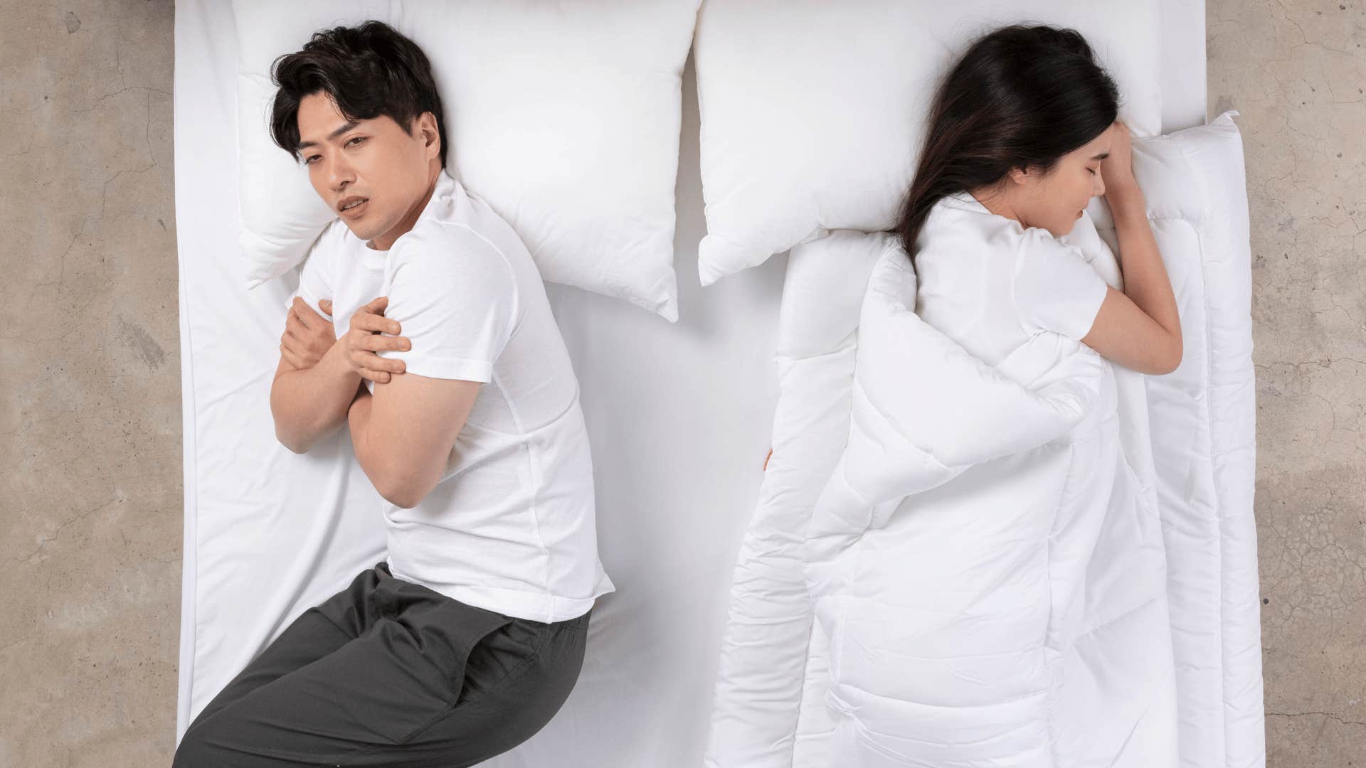 man wondering if sharing a blanket is worth the hassle as he freezes beside woman