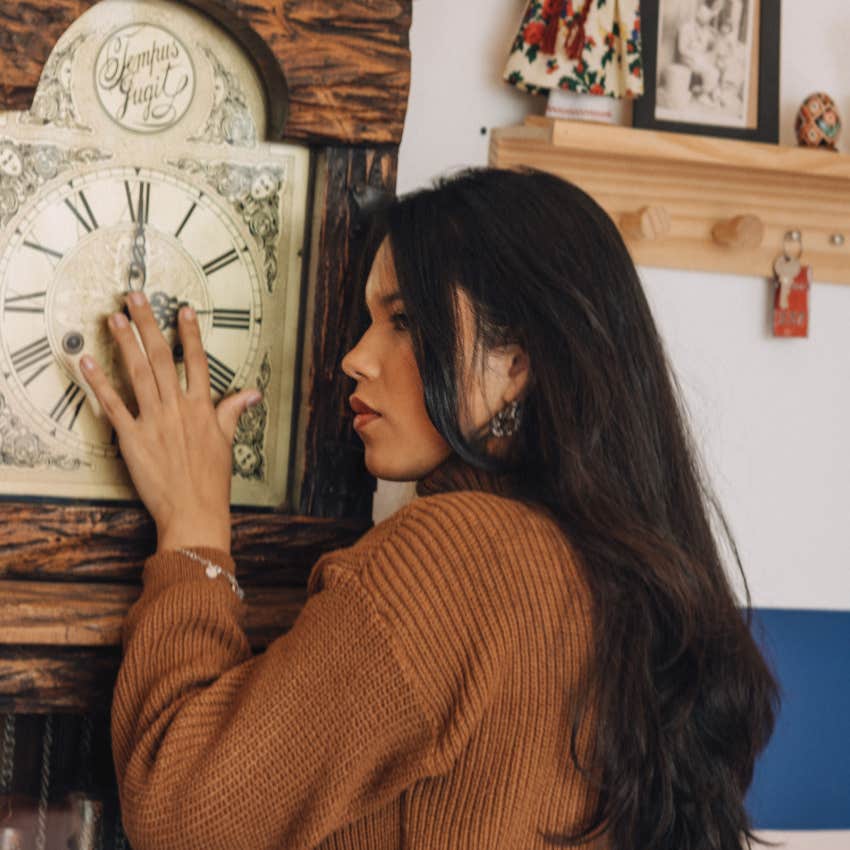 nervous woman listening to and touching creepy clock ticking