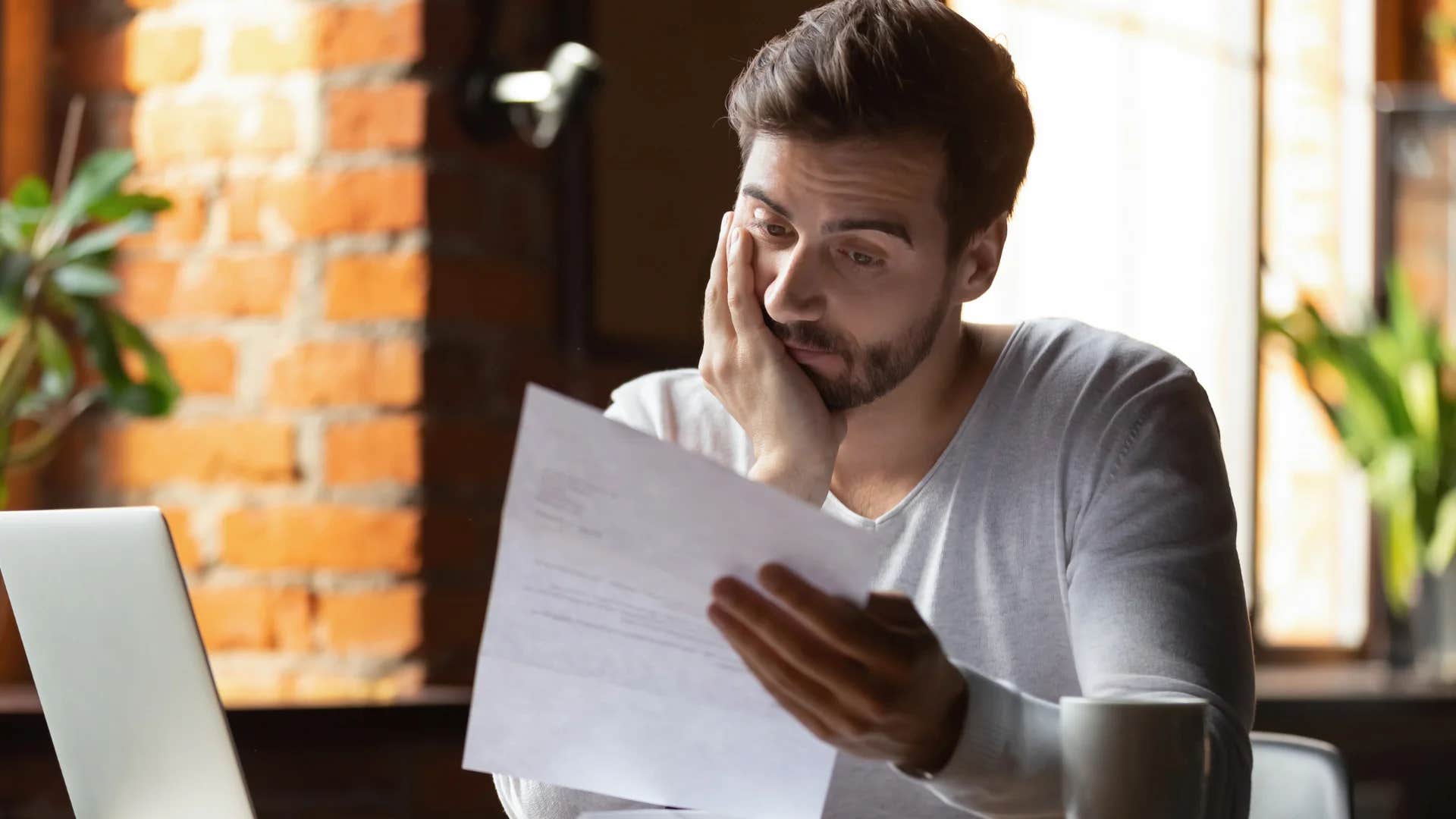 man unbothered looking at bill due to experience with crises