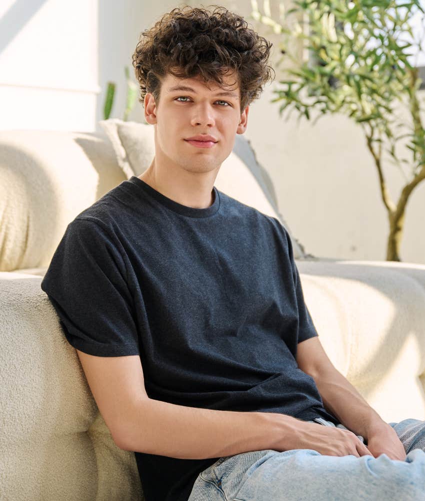 Gen Z young man sitting by a house making a funny face