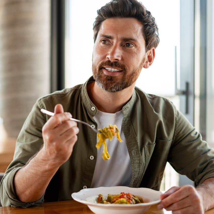 man eating a bowl of pasta even though he isn't hungry because he grew up having to finish everything on his plate