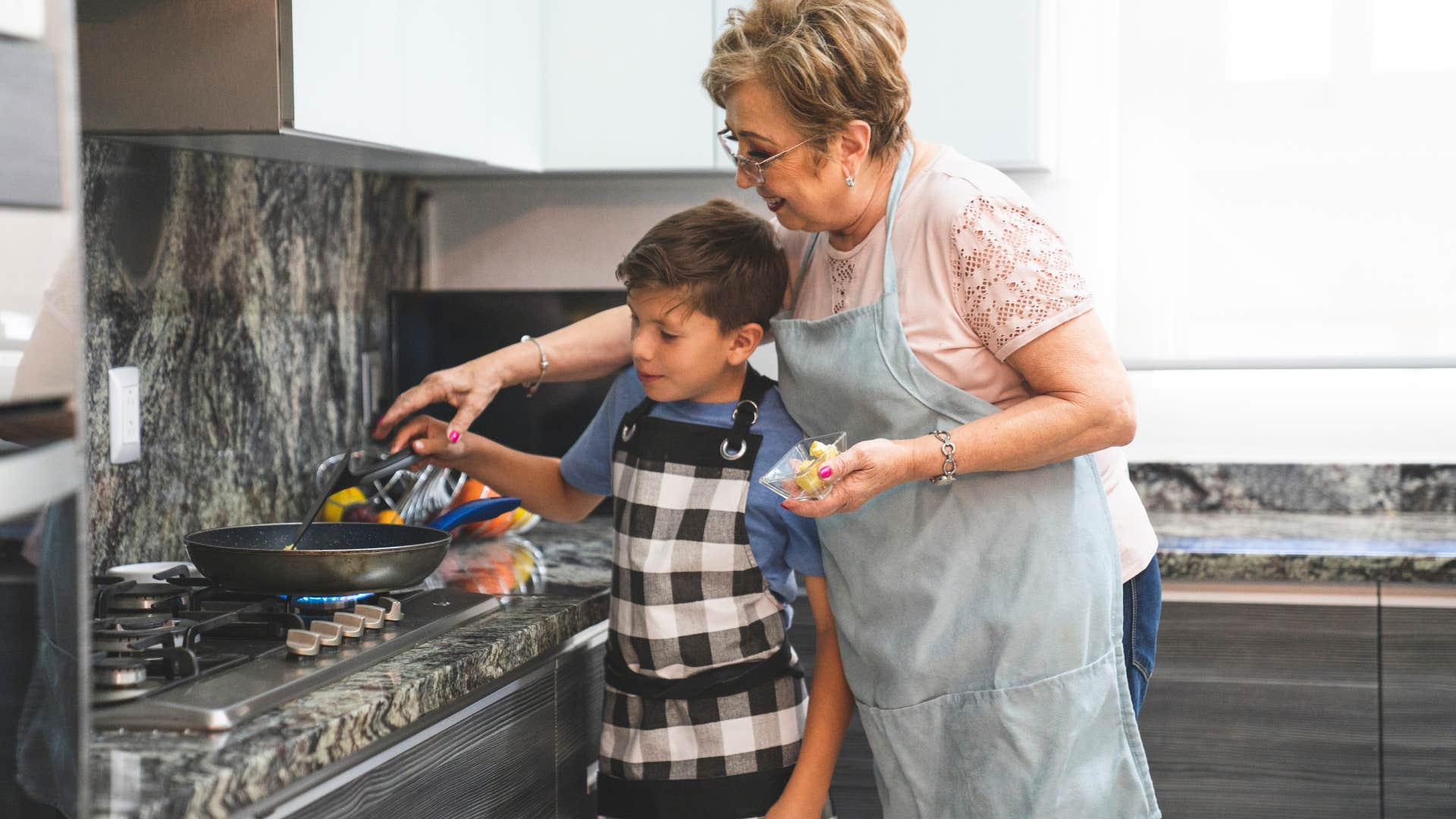 boomer woman throwing a meal together with her grandson