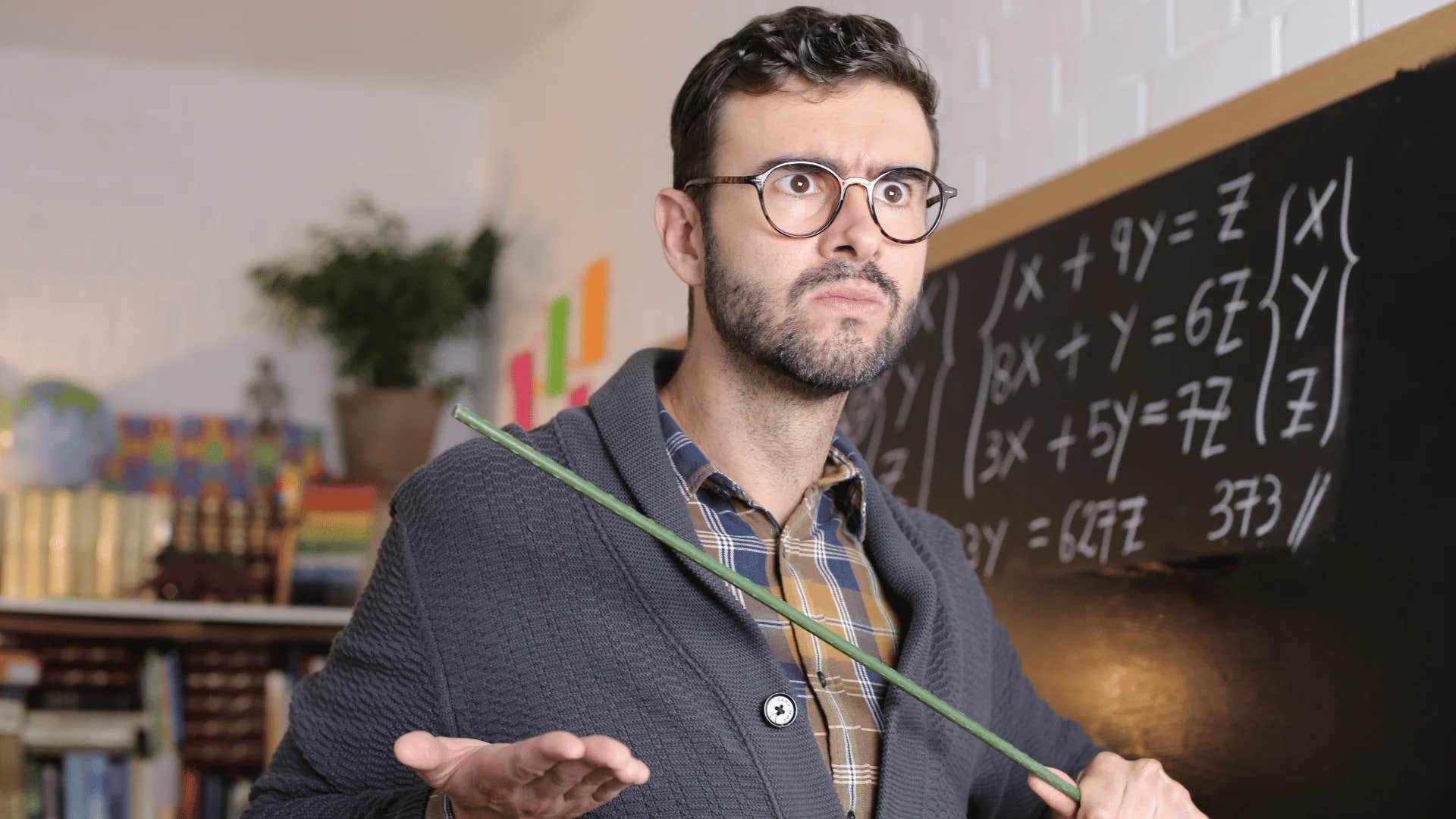 teacher standing in front of traditional chalkboard