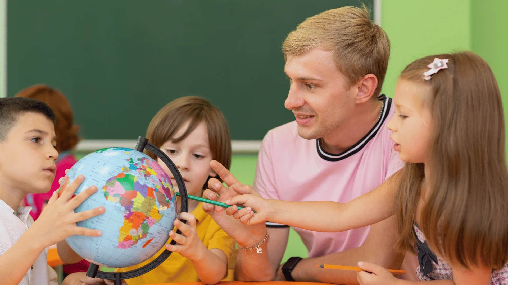 teacher showing physical globe to students