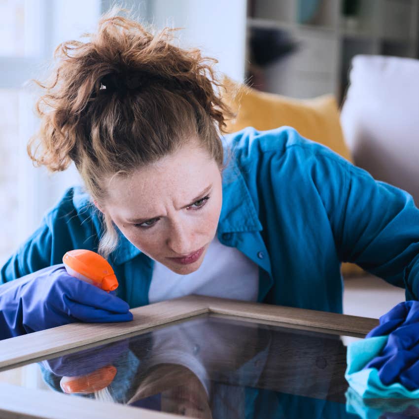 Millennial woman cleaning out of necessity and looking annoyed