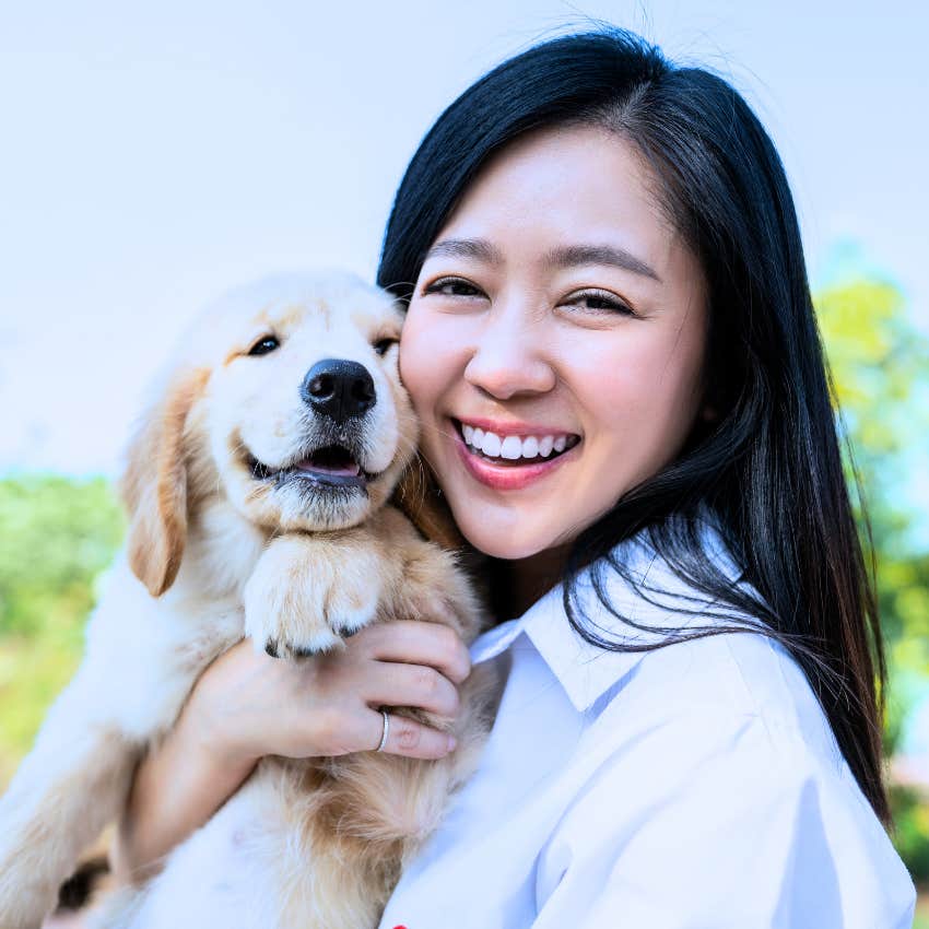 millennial woman holding her dog like it's her child