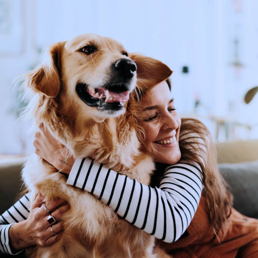 Gen Z woman hugging her dog smiling
