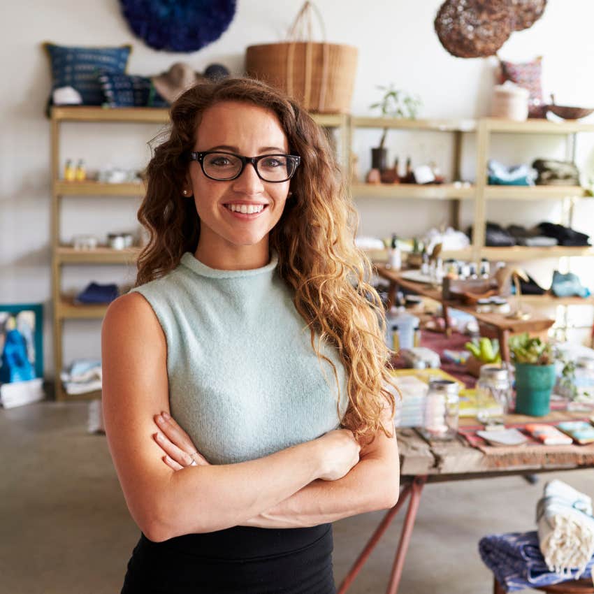 stylish millennial woman at work crossing her arms and smiling