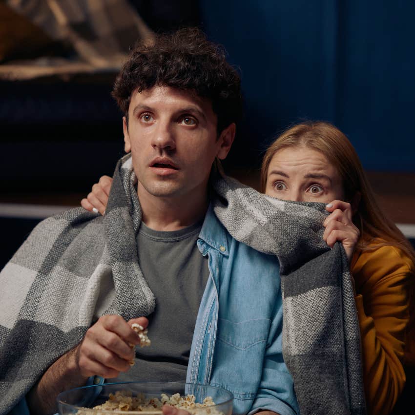 millennial couple watching scary movies on halloween