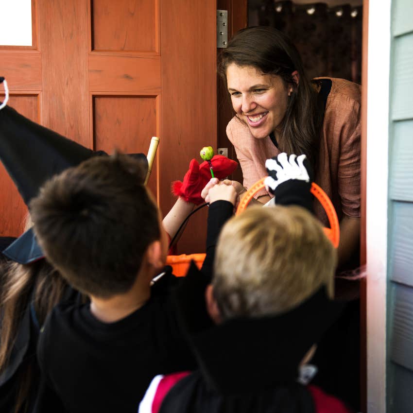 millennial woman handing out candy on halloween wants everyone to have fun