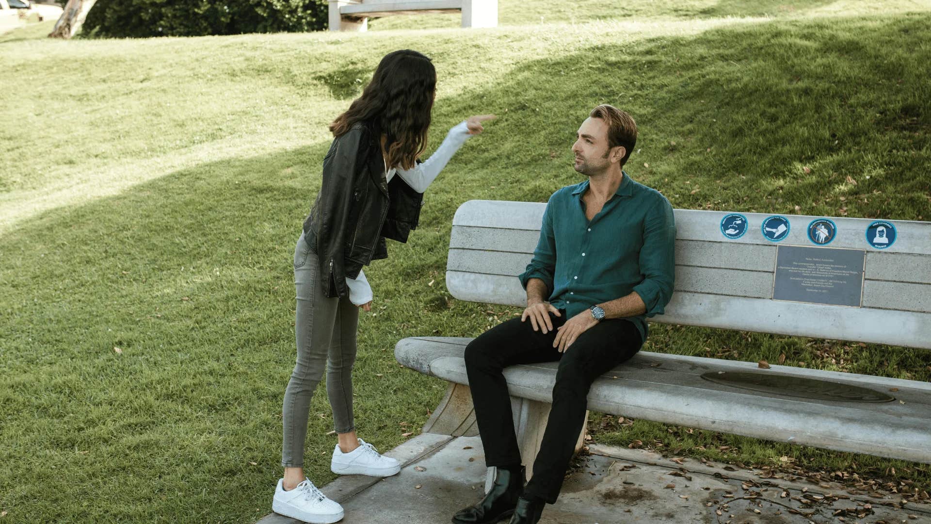 emotionally difficult woman playfully slapping her boyfriend on a park bench