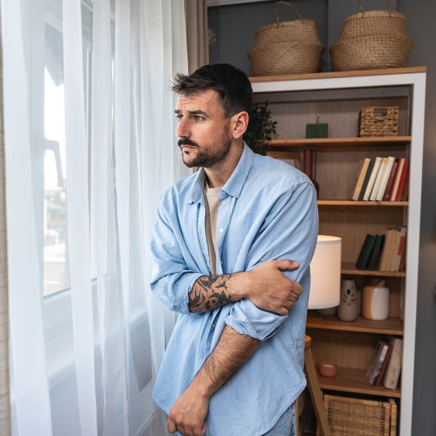 man raised by narcissistic parents looking out window has a difficult time relaxing and having fun