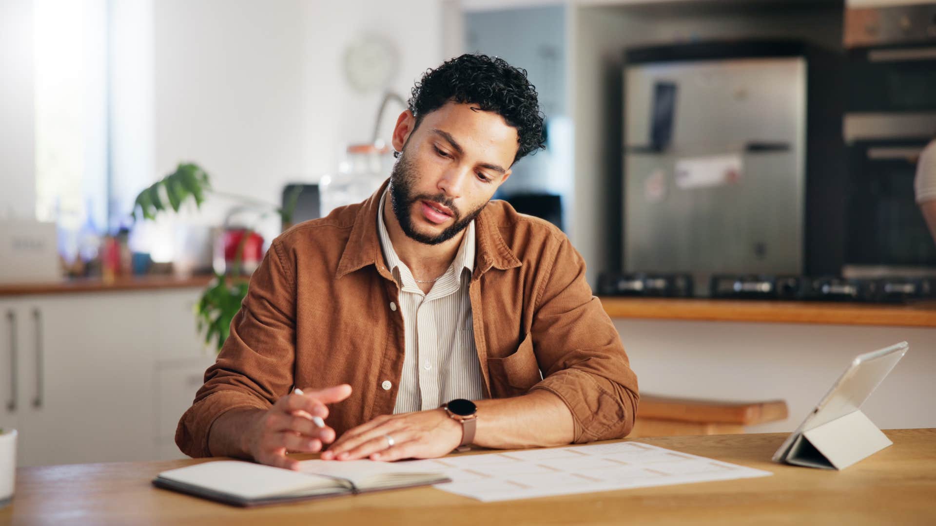 man using a paper calendar to plan out his weeks in advance