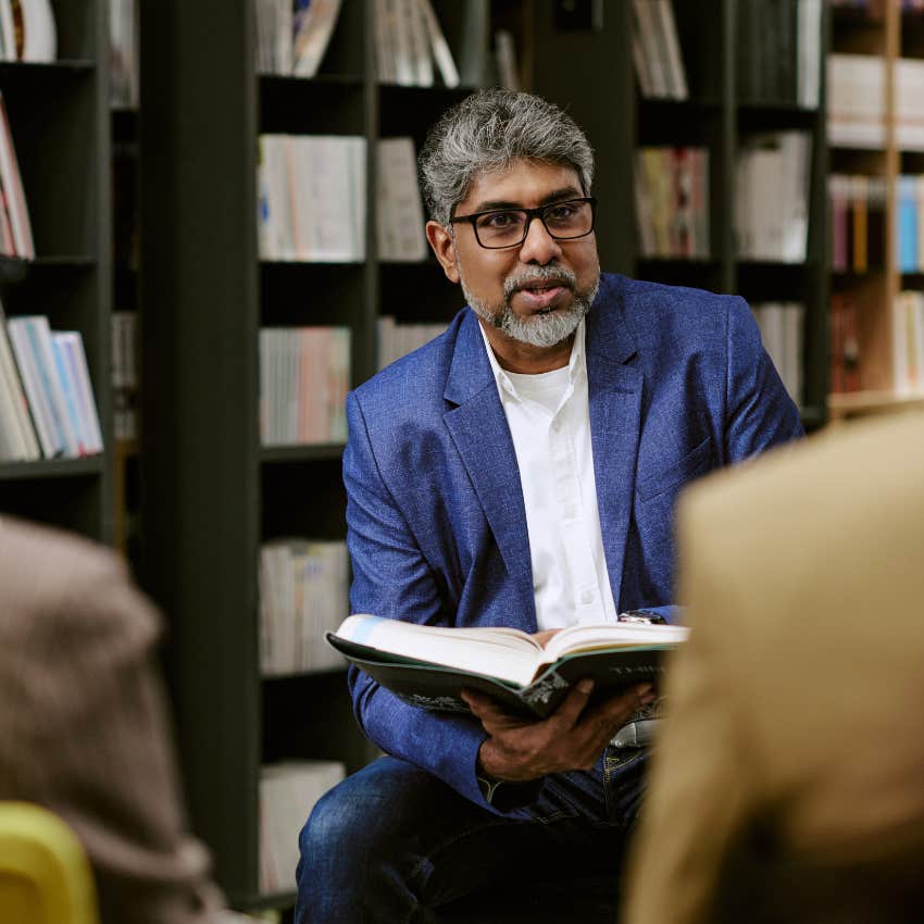 highly intelligent man who's wildly curious holding a book