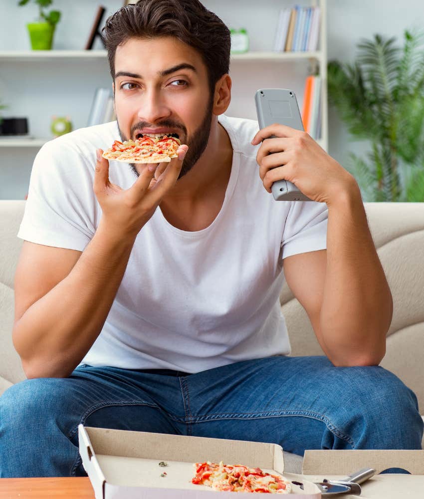 Man watching TV and eating unhealthy food