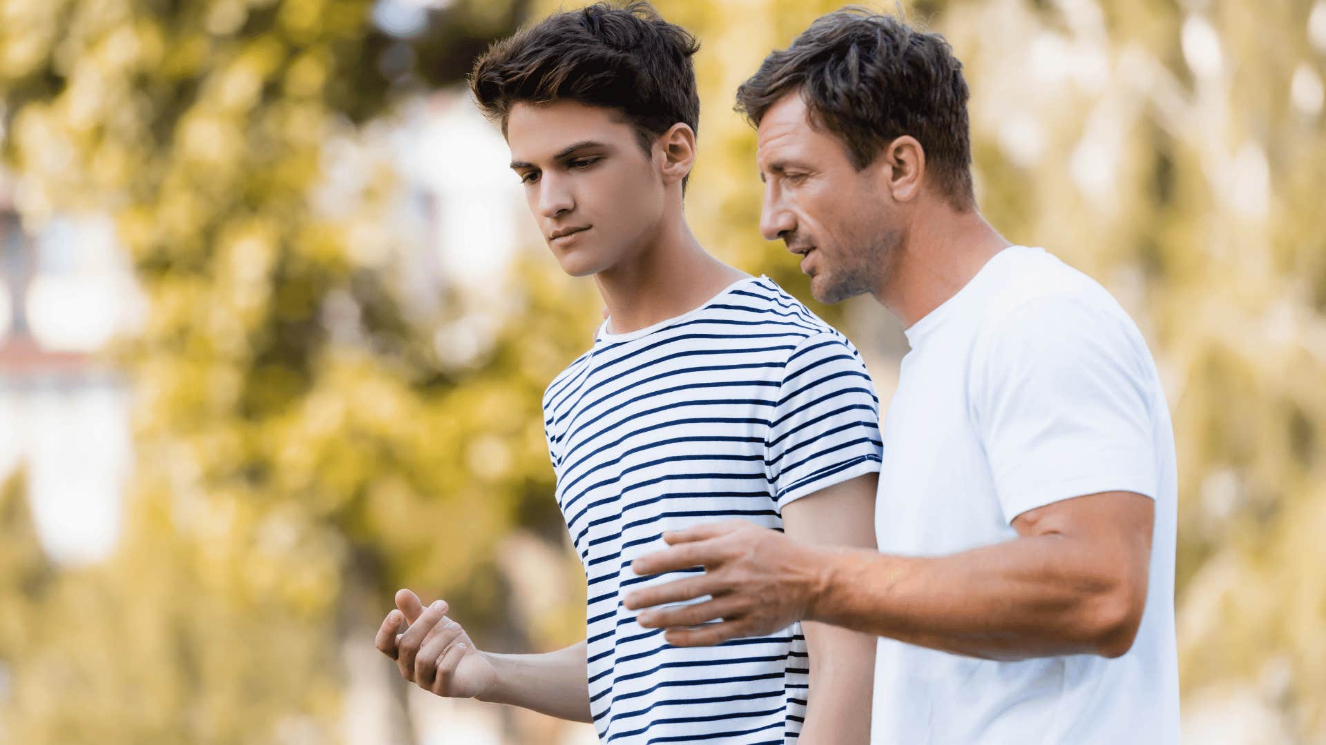 father in white shirt telling son you'll get over it as they walk