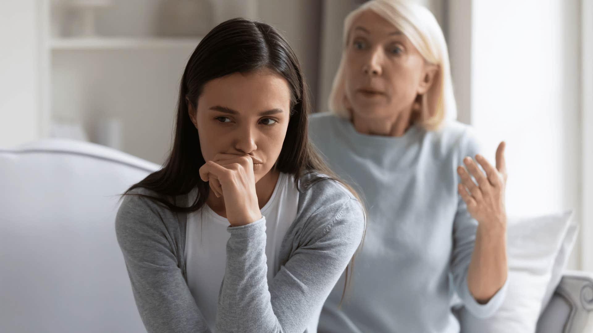 mother in blue shirt telling daughter you're fine as daughter looks upset