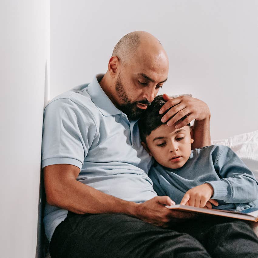 father validating his son while kindly reading him a book