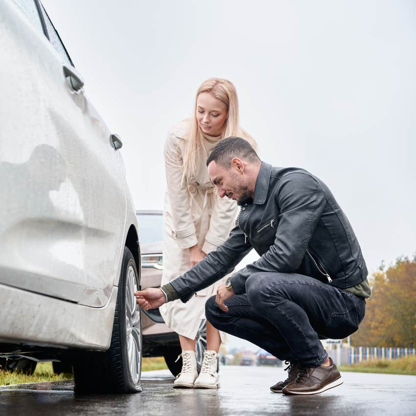millennial man doing a woman a favor checking her tires