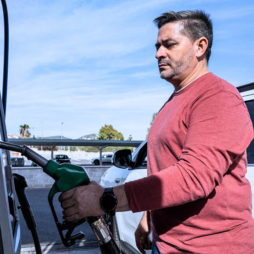 serious man pumping gas feeling annoyed by high prices