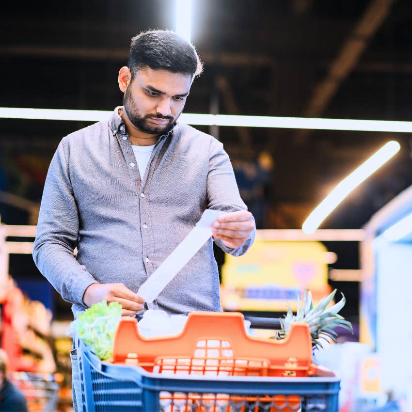 man looking at his grocery store receipt frustrated at prices