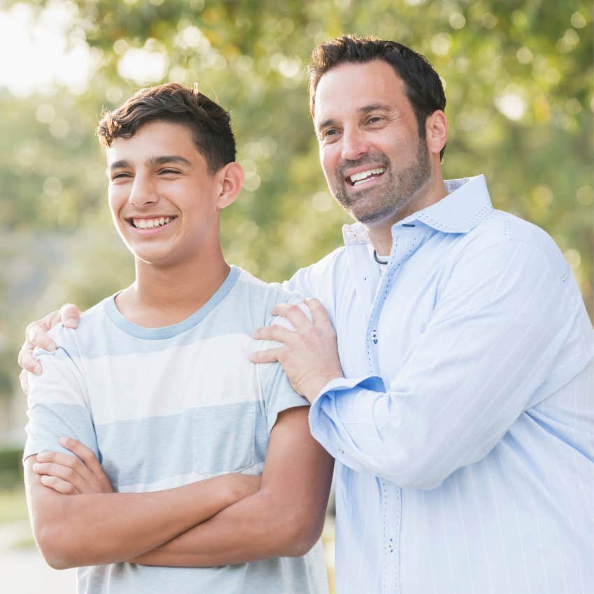dad putting his arm around oldest child standing outside