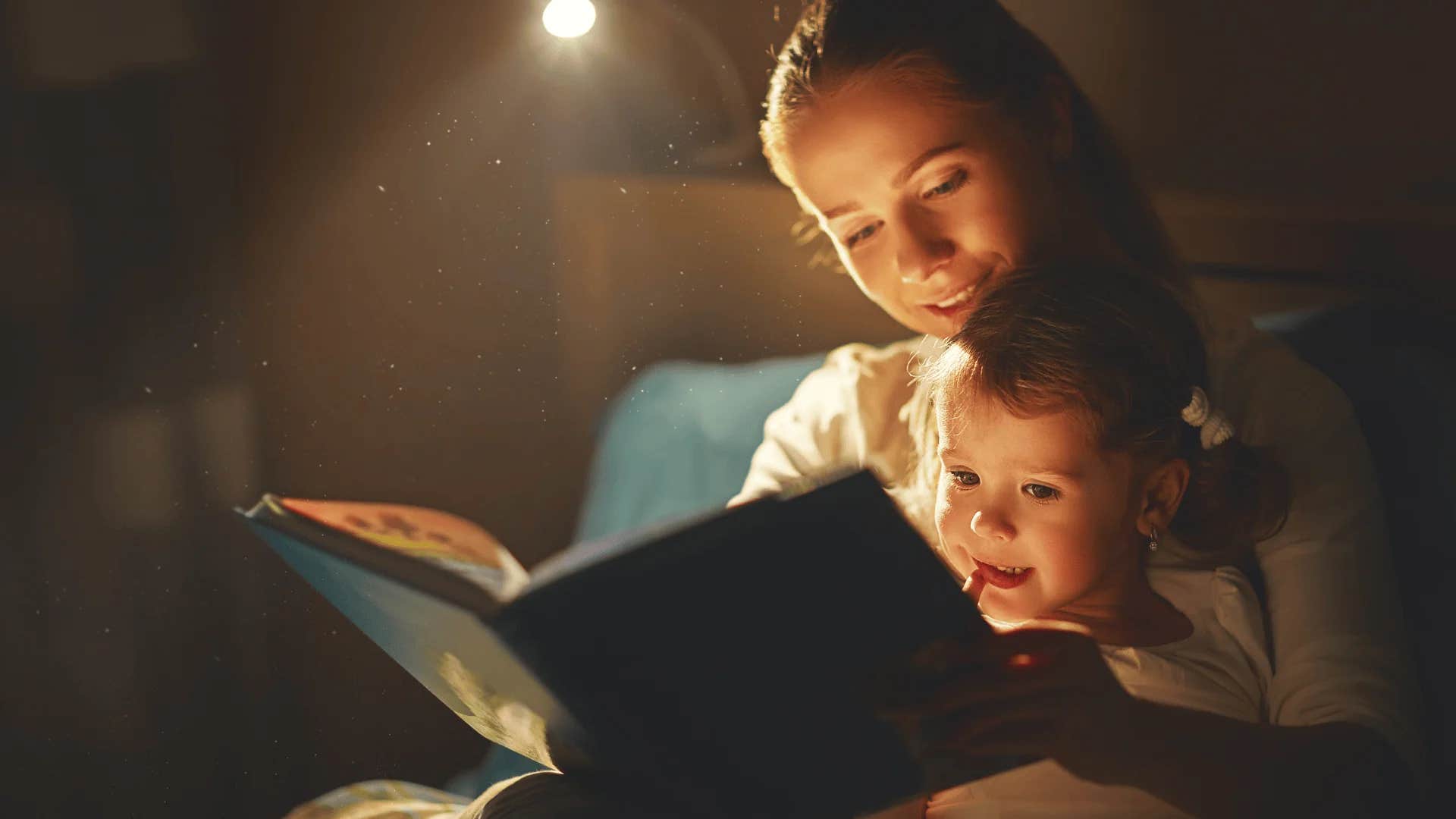 mom bonding with her child reading to him before bed