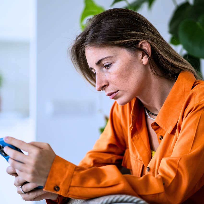 Woman looking exhausted by bad news on her phone