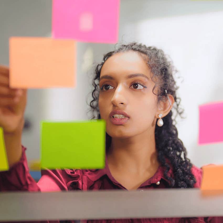 young woman who feels emotionally lighter speaking to herself via sticky notes
