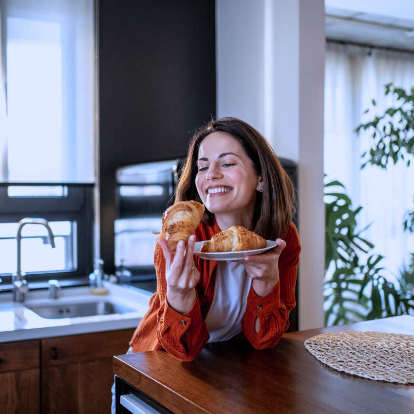 happy calm woman eating a sweet treat she baked at home