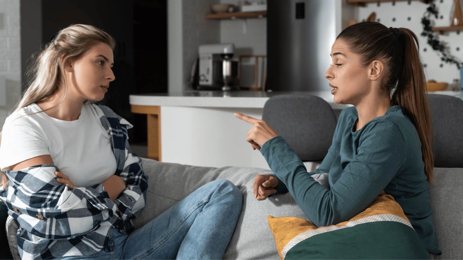 woman in blue shirt pointing at friend as she tells her don't double down now