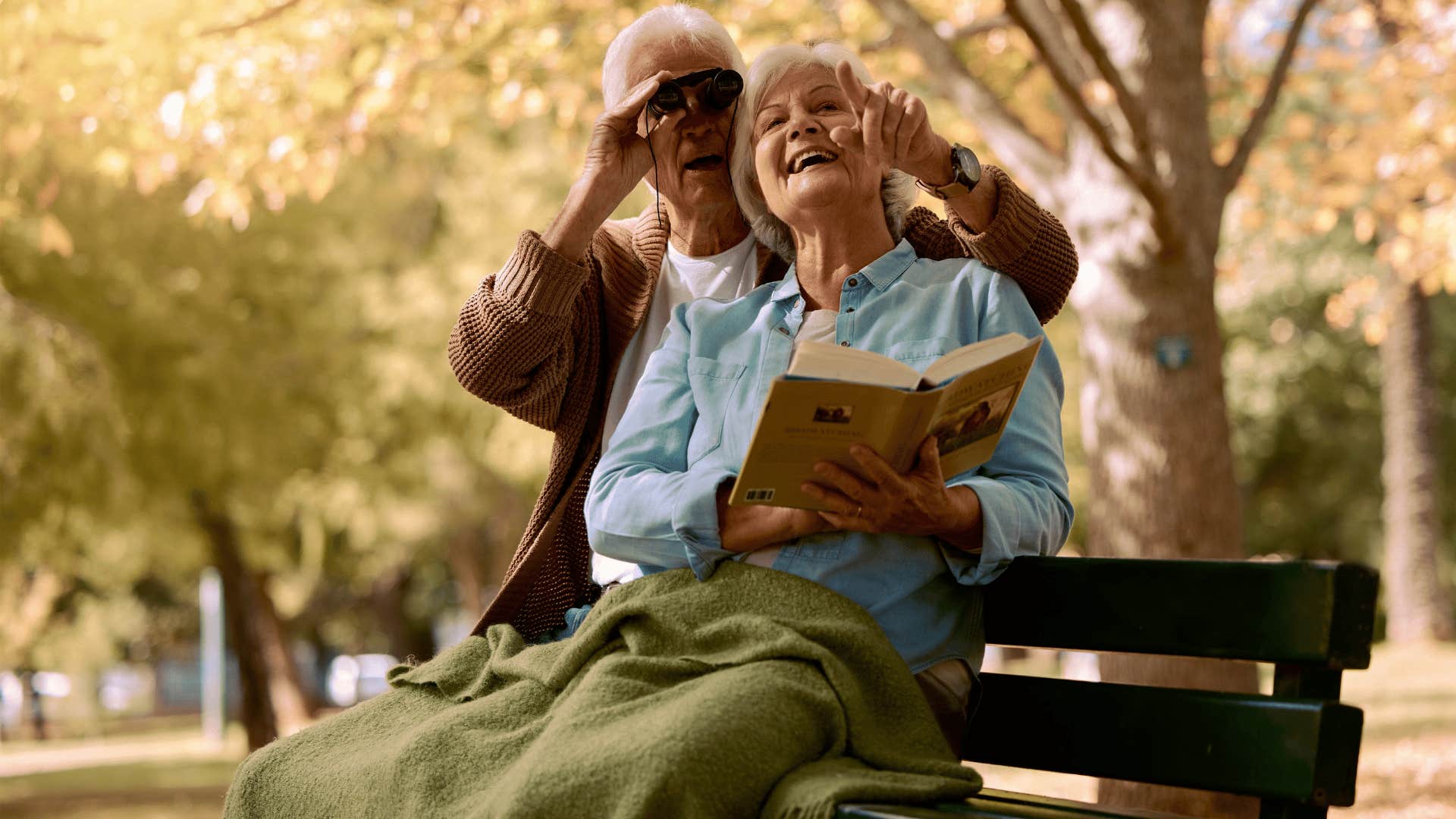 couple birdwatching on bench