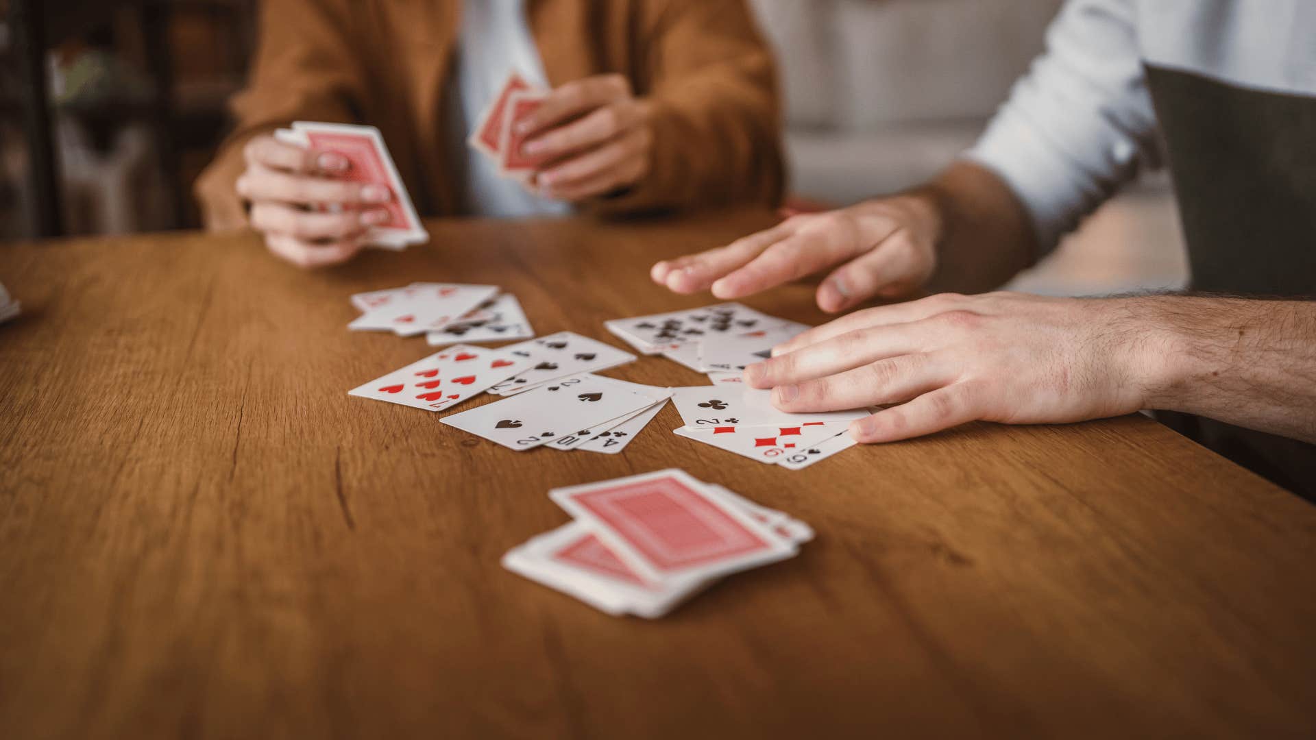 people playing cards while sitting at table