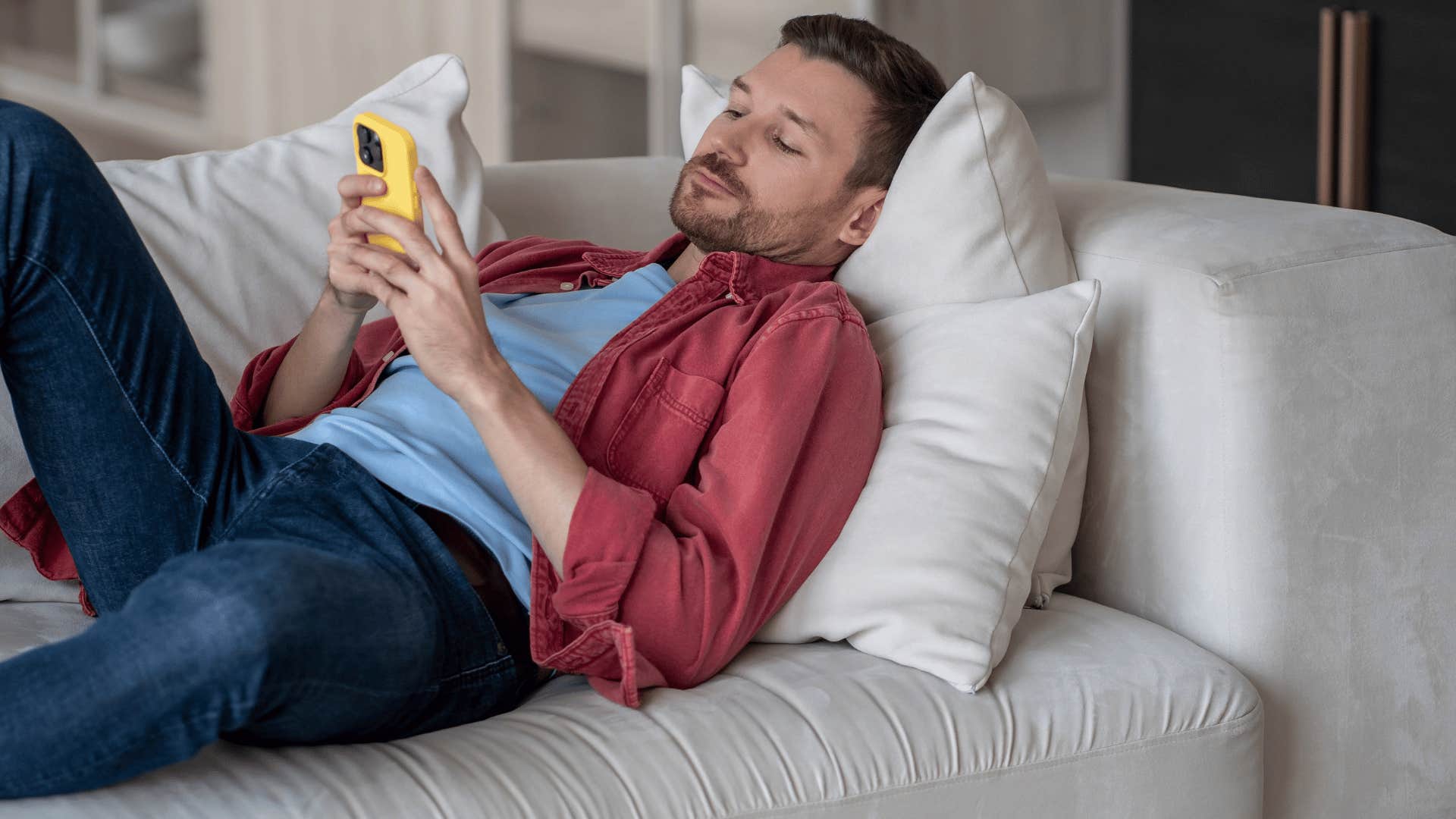 man lazily on the phone scrolling as he says i don't feel like it