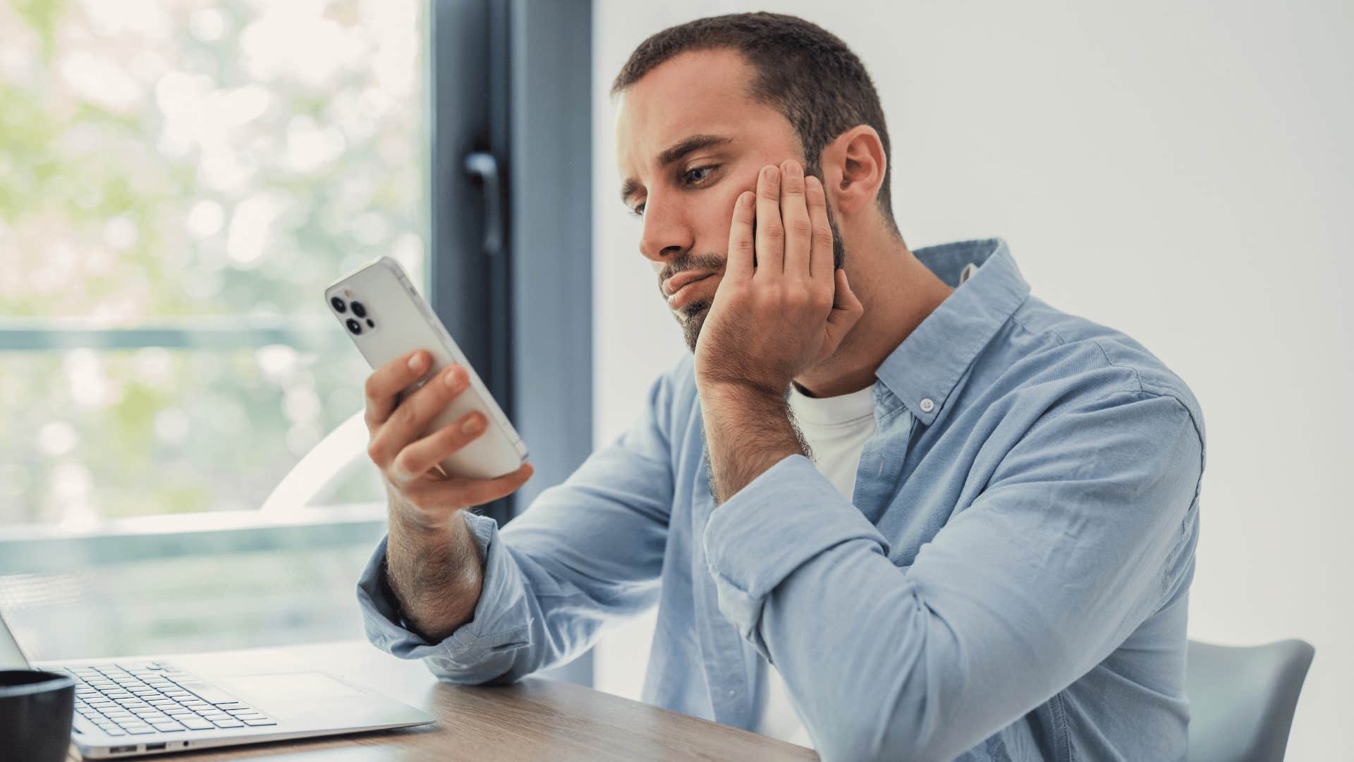 man in jean jacket on the phone thinking i'll do it later