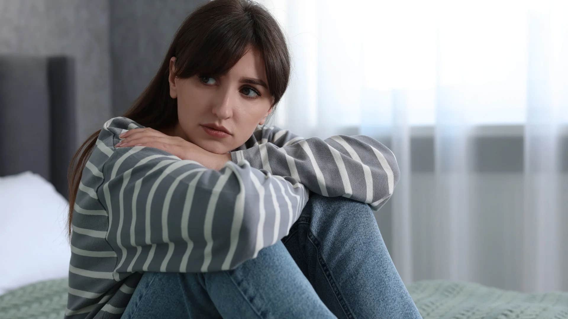 young woman making herself more miserable than she needs to be telling herself i'm lonely
