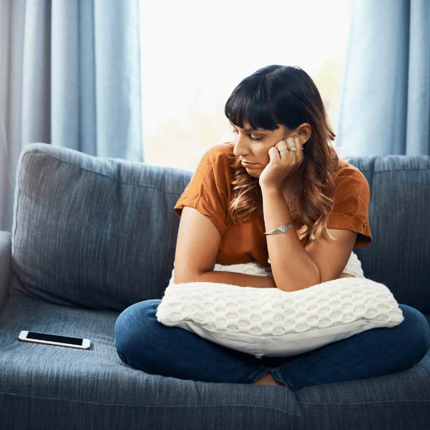 woman staring longingly at phone spending time apart from partner