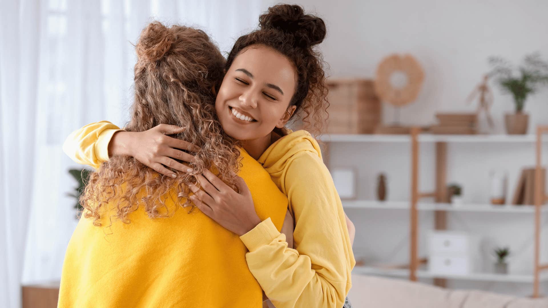 friend in yellow hoodie hugging friend as she says i don't need to win every argument