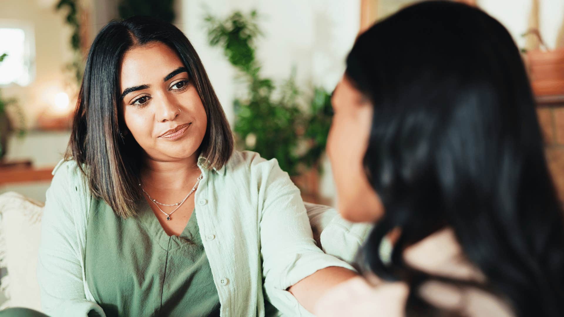 woman in green shirt comforting friend as she says i see where you're coming from