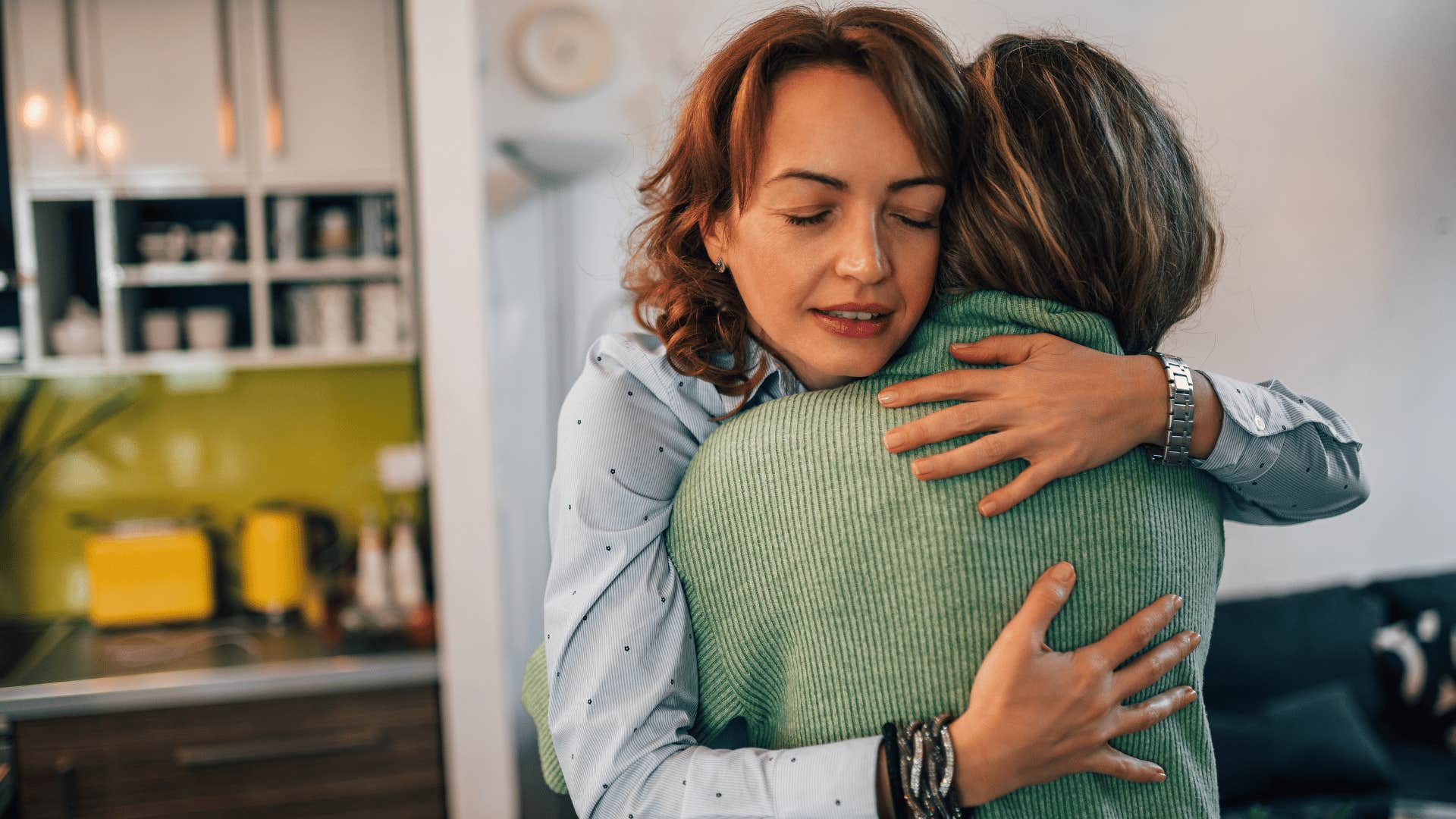 woman in blue shirt hugging friend as she says i take full responsibility for that