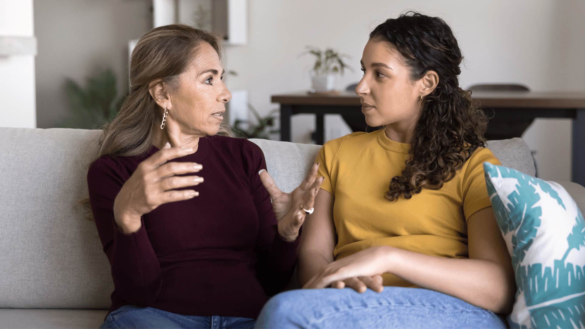 woman in red shirt telling daughter i'm got going to hold that against you