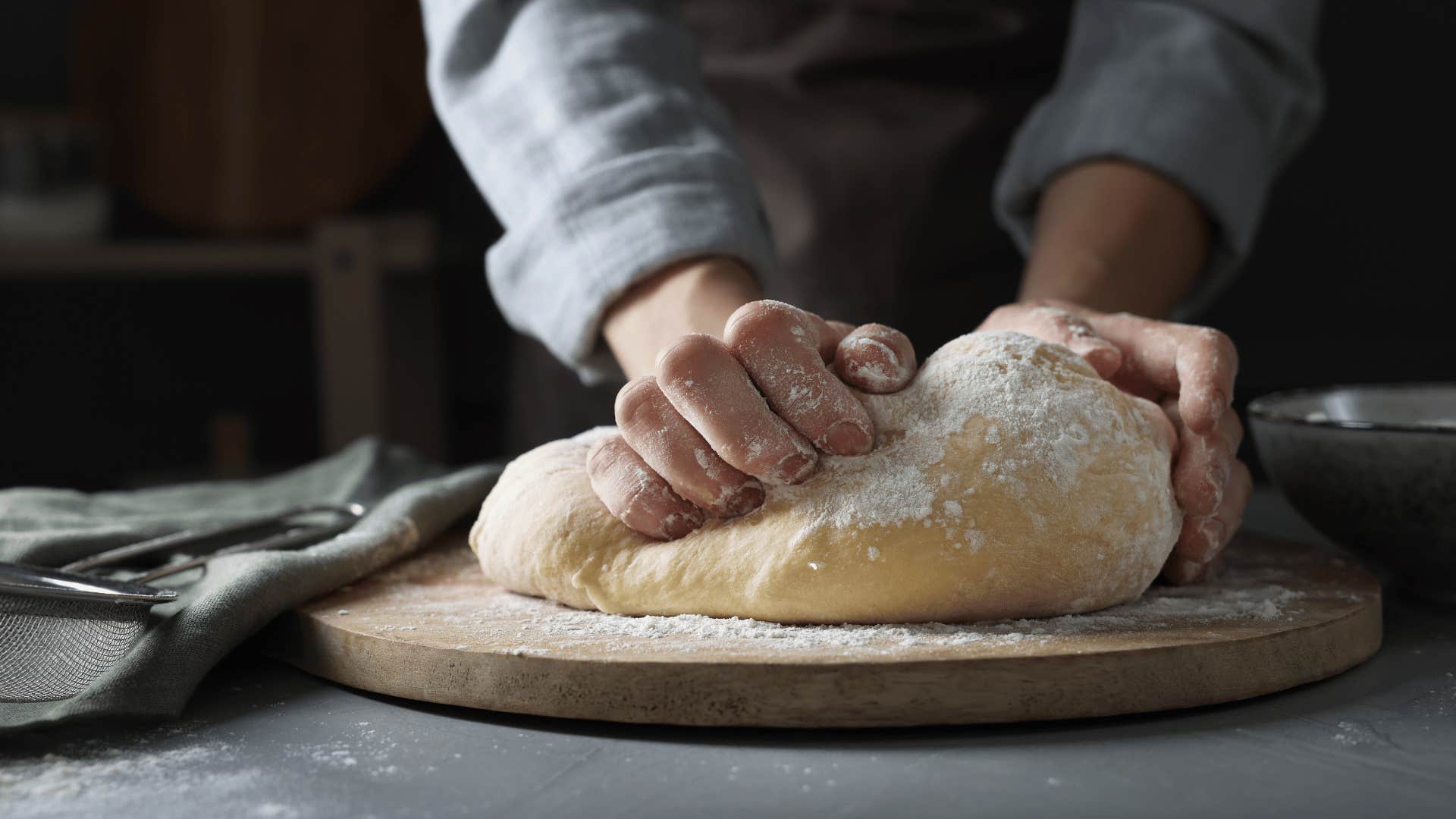 person kneading bread as they are baking homemade goods