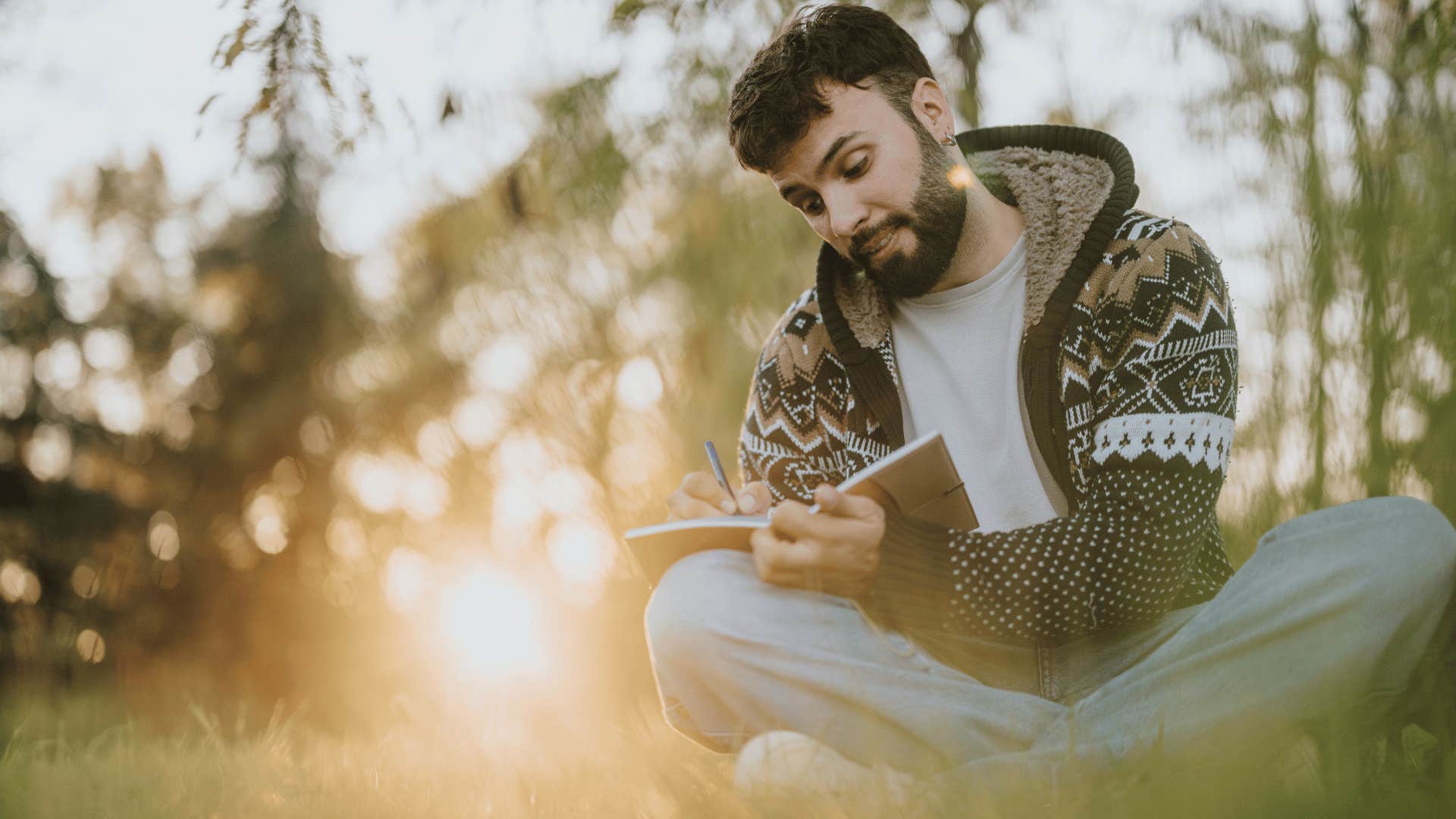 man in white shirt journaling their thoughts and feelings outside