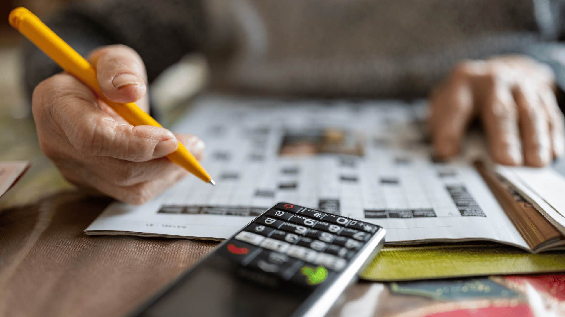 man solving crossword puzzles