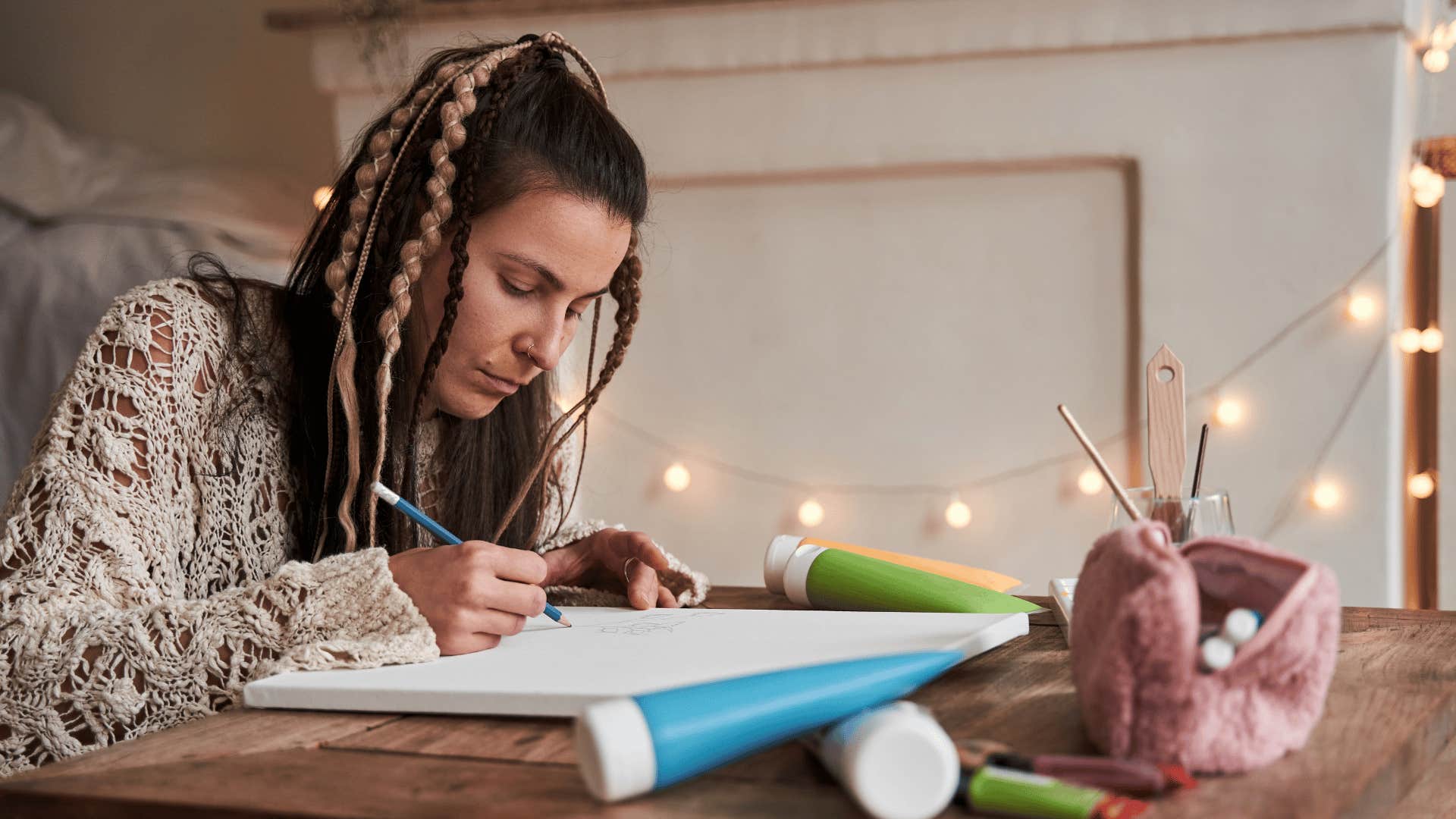 woman with white shirt drawing or sketching at desk
