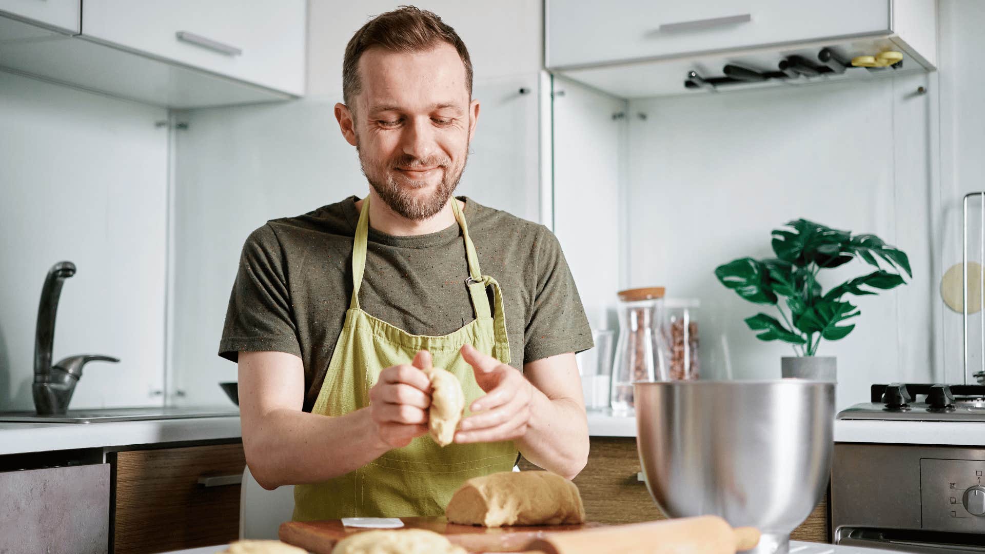 man in green shirt making homemade bread