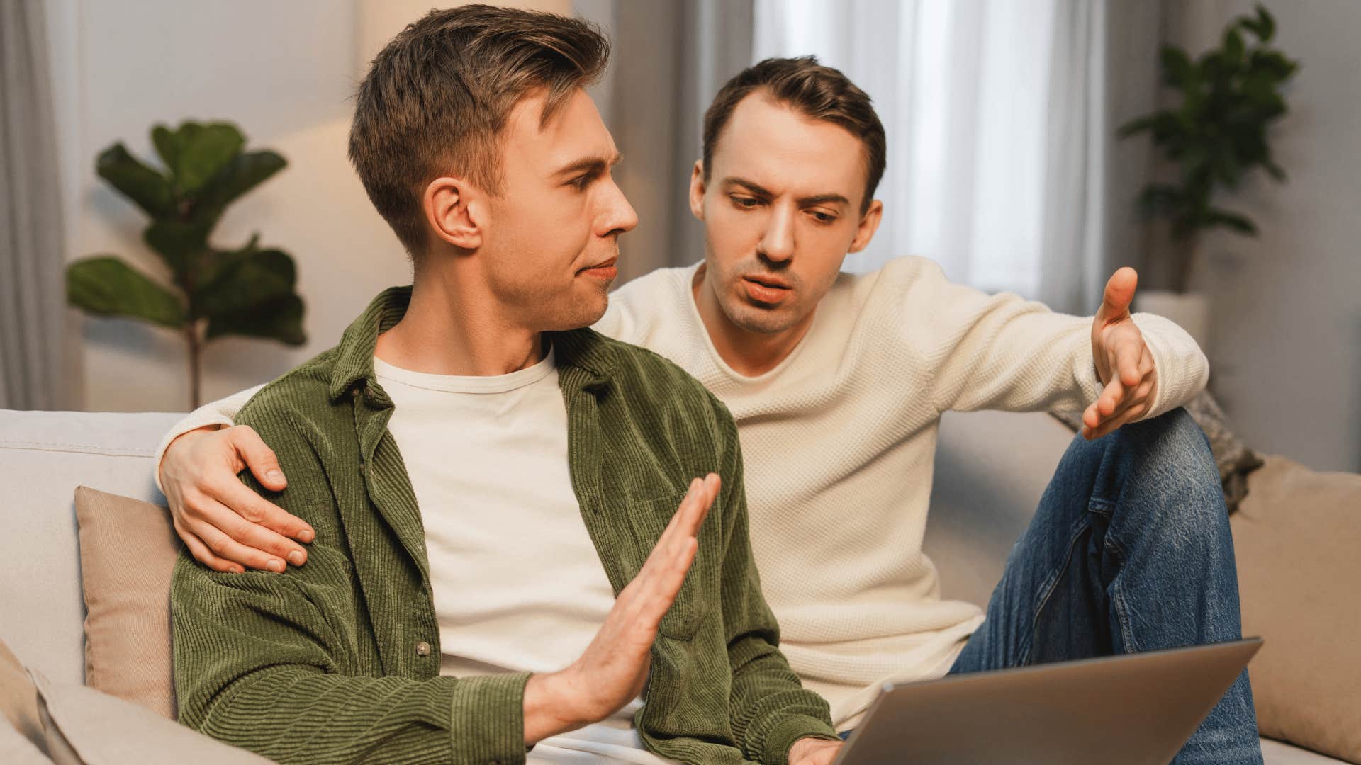 man in green jacket holding up hand as he says i don't even want to hear it